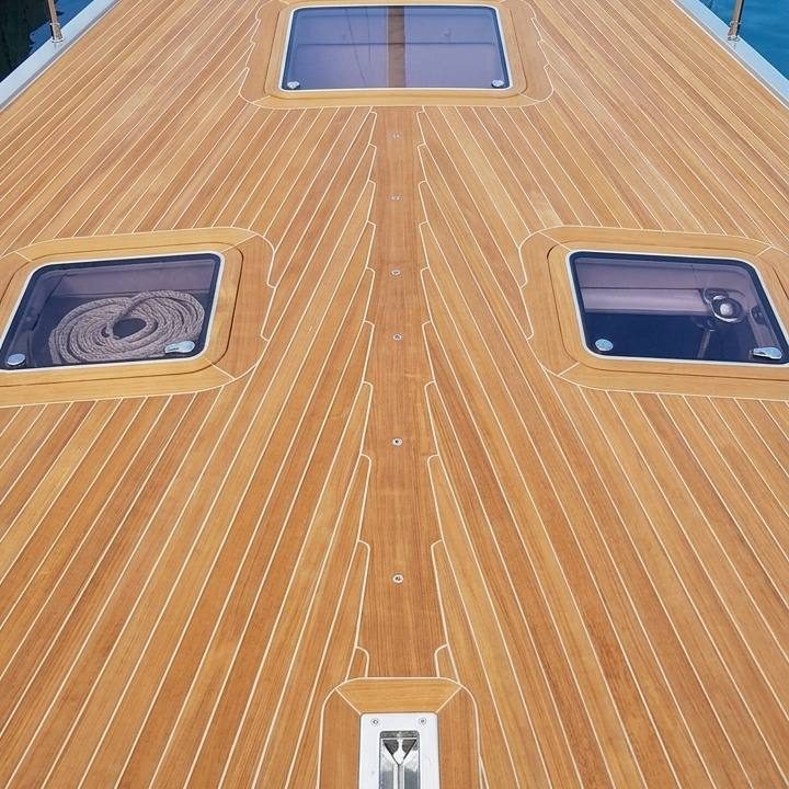 Solid teak deck laid around flush hatches and deck lights